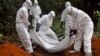 Health workers bury the body of a woman who is suspected of having died of the Ebola virus in Bomi county, on the outskirts of Monrovia, Liberia, Monday, Oct. 20, 2014. Liberian President Ellen Johnson Sirleaf said Ebola has killed more than 2,000 people in her country and has brought it to "a standstill," noting that Liberia and two other badly hit countries were already weakened by years of war. (AP Photo/Abbas Dulleh)