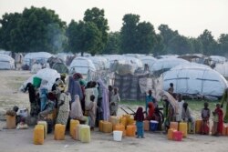 FILE - People displaced by Islamist extremists queue for water at the Muna camp, in Maiduguri, Nigeria, Aug. 30, 2016.