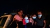 FILE - Migrants from Honduras wait in a Border Patrol truck after turning themselves in upon crossing the U.S.-Mexico border. The U.S. government continues to report large numbers of migrants crossing the border, with an increase in adult crossers. 