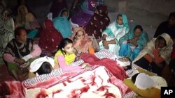 Des Pakistanais pleurent la mort d'un de leur proche, qui a succombé après avoir bu un alcool empoisonné, à Toba Tek Singh, au Pakistan, le 26 décembre 2016. 