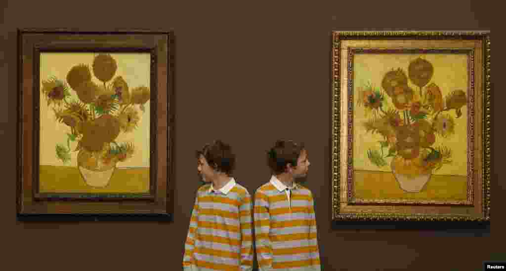 Si Kembar Edgar (kiri) dan Gabriel berpose untuk para juru foto di antara dua lukisan Vincent van Gogh, Bunga Matahari 1888 (kiri) dan Bunga Matahari 1889 di Galeri Nasional di London. Kedua lukisan itu "dipertemukan" di London untuk pertama kalinya dalam 65 tahun dan akan dipamerkan selama tiga bulan dari tanggal 25 Januari 2014.