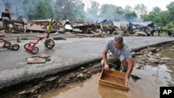 Mark Lester nettoie quelques rares objets qu’il a pu récupérer après des inondations qui ont endommagé plus de 100 maisons et privé d'électricité des dizaines de milliers de foyers et d'entreprises à White Sulphur Springs, Virginie occidentale, 24 Juin 2016. (AP Photo / Steve Helber)