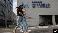 2020年8月7日戴着口罩的行人走过TikTok北京总部大楼