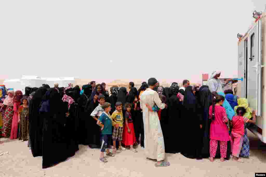 Displaced people, who fled from Falluja because of Islamic State violence, stand in line for treatment at a refugee camp in Ameriyat Falluja, south of Falluja, Iraq.