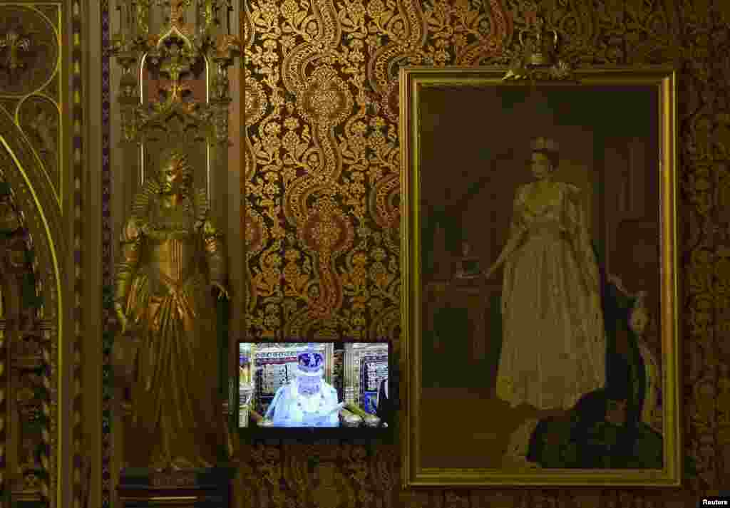 Britain's Queen Elizabeth is seen on a screen as she delivers her speech during the State opening of Parliament in the House of Lords, at the Palace of Westminster in London.