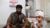 FILE - A boy who was injured boy in a deadly attack on a market sits on the ground at a hospital in Helmand province, June 29, 2020.