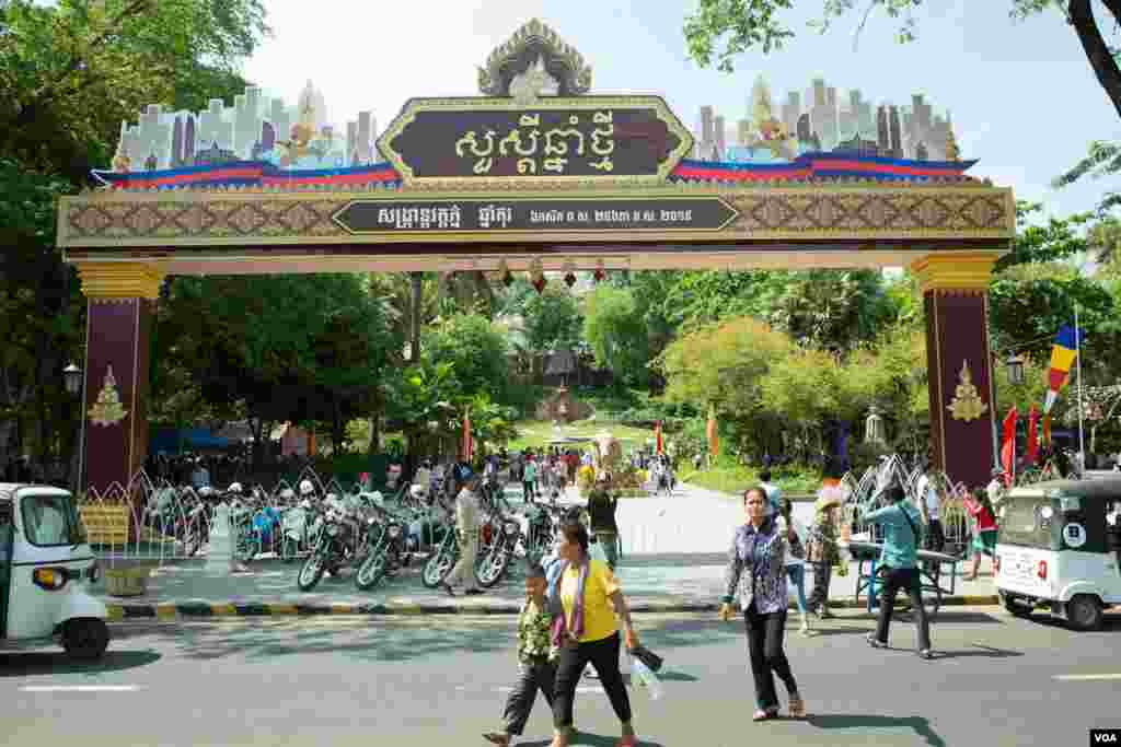 ប្រជាជនខ្មែរដើរនៅខាងមុខក្លោងទ្វារសង្រ្កាន្តនៅរមណីយដ្ឋានវត្តភ្នំ អំឡុងកម្មវិធីសង្រ្កាន្តវត្តភ្នំដើម្បីអបអរពិធីបុណ្យចូលឆ្នាំប្រពៃណីខ្មែរនៅក្នុងថ្ងៃទីពីរ កាលពីថ្ងៃទី១៥ ខែមេសា ឆ្នាំ២០១៩ ក្នុងរាជធានីភ្នំពេញ ប្រទេសកម្ពុជា។(ទុំ ម្លិះ/VOA)