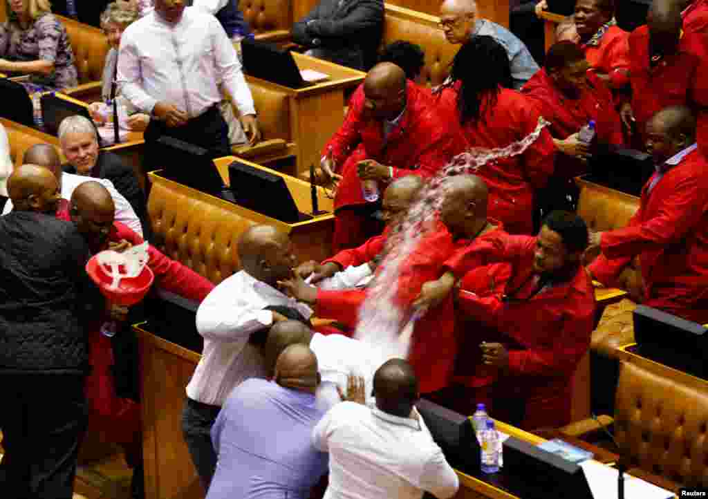 Party leader Julius Malema and members of his Economic Freedom Fighters (EFF) clash with Parliamentary security as they are evicted from the chamber in Cape Town, South Africa.