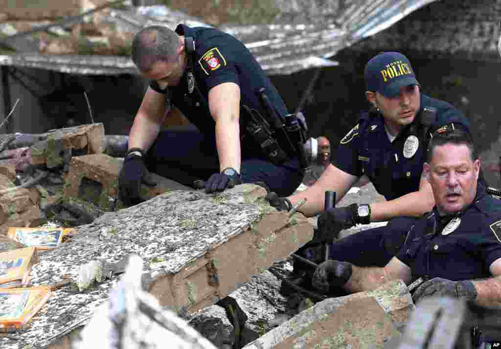 Polisi Moore menggali reruntuhan Sekolah Dasar Plaza Towers yang roboh akibat tornado di Moore, Oklahoma (20/5). (AP/Sue Ogrocki)