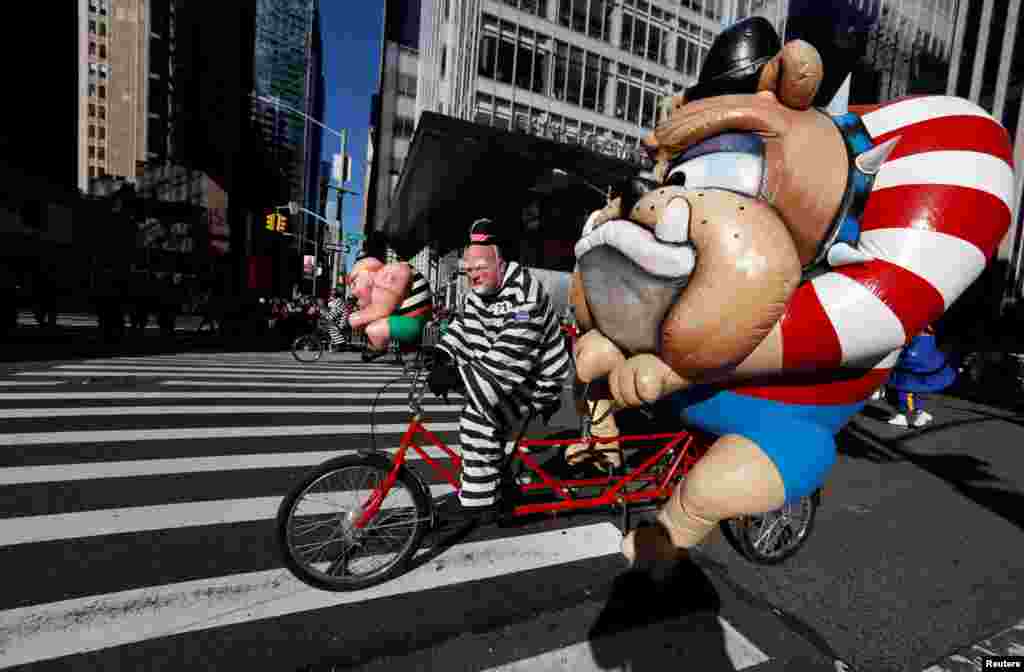 People dressed as cartoon characters on tandem bicycles make their way down 6th Ave during the 91st Macy's Thanksgiving Day Parade in the Manhattan borough of New York City, Nov. 23, 2017.