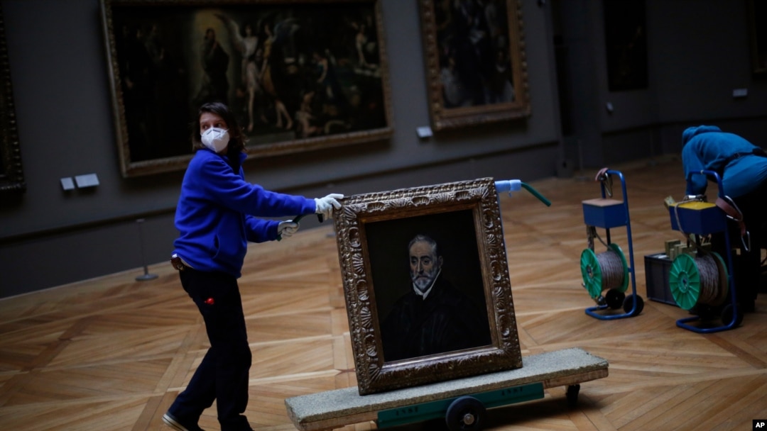 A worker moves the painting "Portrait of Antonio de Covarrubias y Leiva" by Spanish painter El Greco, at the Louvre museum, in Paris, France, Feb. 9, 2021, as the COVID pandemic gives staff a rare opportunity to tackle long-overdue refurbishments. 