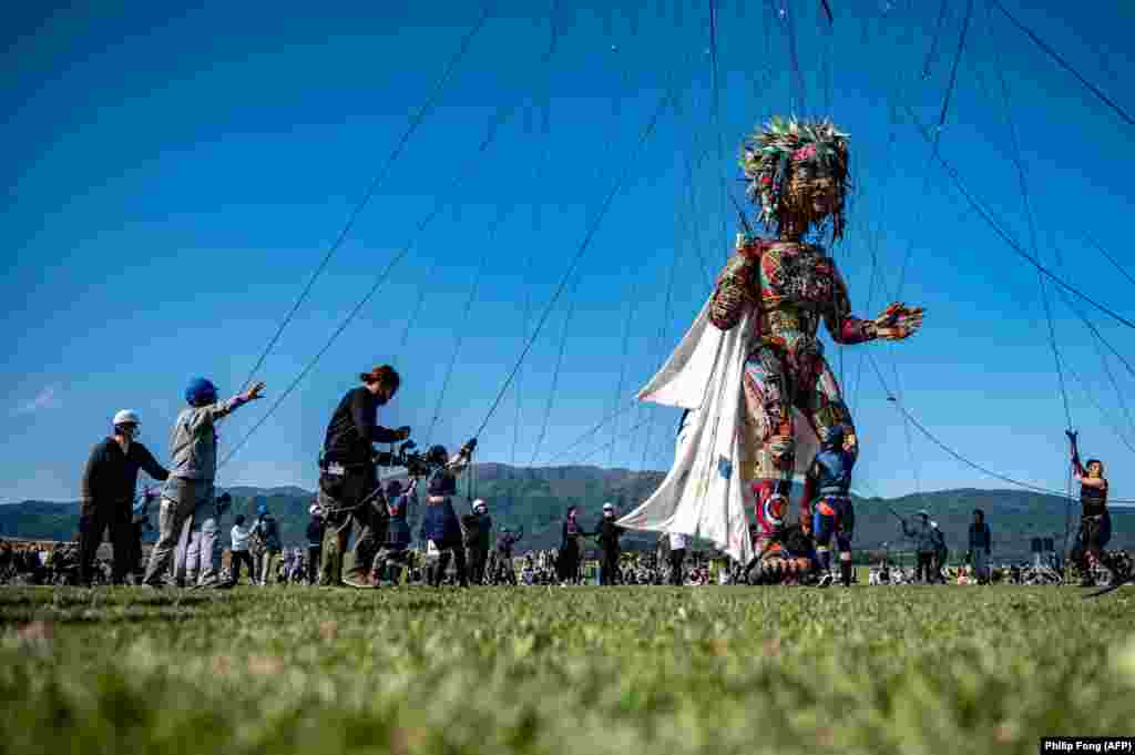 Performers and staff control the giant puppet &#39;MOCCO&#39; designed by Noriyuki Sawa during the &quot;Rediscover Tohoku - MOCCO&#39;s Journey from Tohoku to Tokyo&quot; media tour at Takata Matsubara Tsunami Reconstruction Memorial Park in Rikuzentakata, Iwate Prefecture, Japan, May 15, 2021.&nbsp;