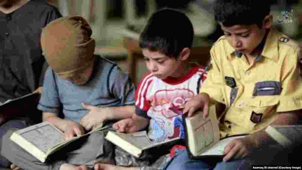 Young boys recite the Quran as part of Islamic State-run school curriculum.