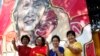 Members of Myanmar opposition National League for Democracy party pose for photos in front of a graffiti art depicting party leader Aung San Suu Kyi created by artist Arker Kyaw outside the party's headquarters in Yangon, Myanmar, Nov 13, 2015.
