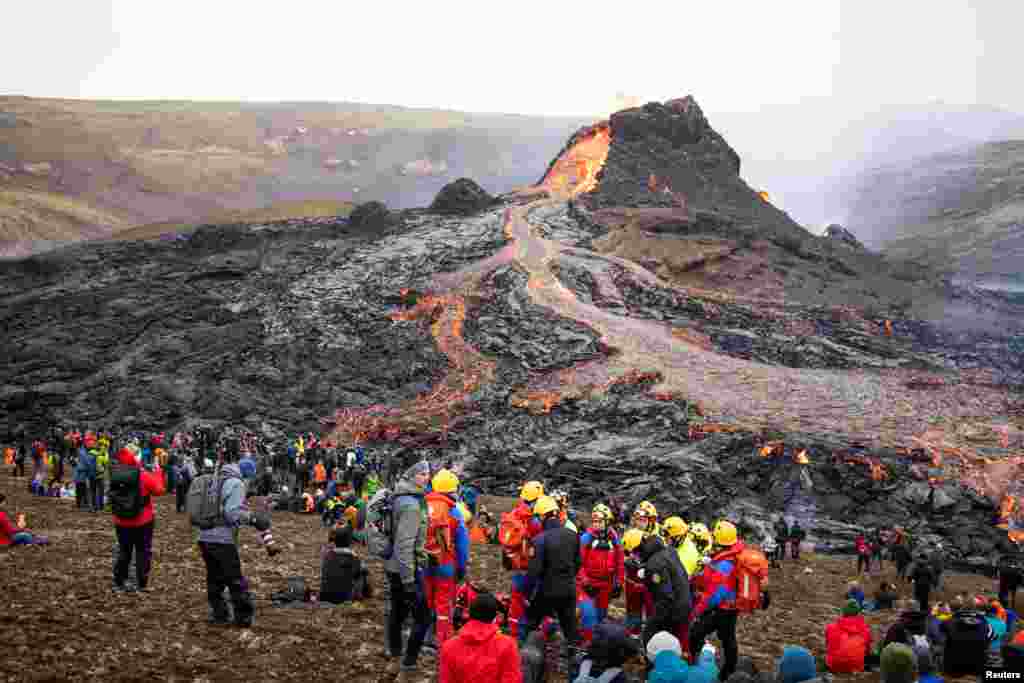 People gather at the volcanic site on the Reykjanes Peninsula following Friday&#39;s eruption in Iceland, March 21, 2021.