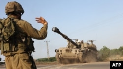 İsrail əsgəri özüyeriyən hovitzer qurğusuna təlimat verir. Aşkelon, İsrail. 8 oktyabr, 2023. 