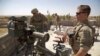 FILE - In this Aug. 20, 2017, file photo, U.S. Army soldiers stand next to a guided-missile launcher, a few miles from the front line, in the village of Abu Ghaddur, east of Tal Afar, Iraq. 