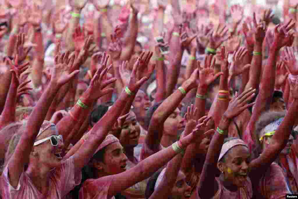 Para peserta bersorak di daerah garis finish lomba lari The Color Run di Pulau Sentosa, Singapura. The Color Run adalah lomba lari 5 kilometer tanpa diukur waktunya yang diselenggarakan di seluruh dunia untuk mendorong gaya hidup sehat dan kegiatan amal di masing-masing tempat. 