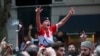 Fans of Serbian tennis star Novak Djokovic celebrate outside the Rialto building believed to be where he was located ahead of the Australian Open in Melbourne, Jan. 10, 2022. 