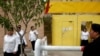 FILE - Ethnic Uyghurs leave a center where political re-education lessons are held in Kashgar, Xinjiang Uyghur Autonomous Region, China, Sept. 6, 2018. The centers are also used for detention.