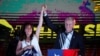 Chilean presidential candidate Jose Antonio Kast and his wife Maria Pia Adriasola Barroilhet raise their hands as he speaks after the partial results of the first round vote during the presidential elections, in Santiago, Chile, November 21, 2021.