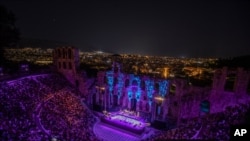 Spectators listen a concert at Odeon of Herodes Atticus as the city of Athens is seen on the background, July 15, 2020.