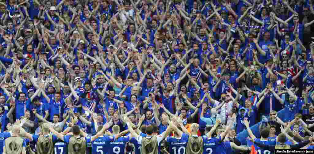 Players for the Iceland national soccer team celebrate with their fans after the final whistle of the UEFA EURO 2016 group F preliminary round match between Iceland and Austria at Stade de France in Saint-Denis, France, June 22, 2016. Iceland won 2-1.