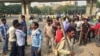 Scores of daily wage workers wait at a major street intersection in the business hub of Gurgaon near New Delhi hoping to find work. (A. Pasricha/VOA)