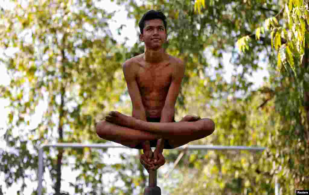 A performer practices "Malkhamb" (traditional Indian gymnastics) during a rehearsal for the upcoming annual Rath Yatra, or chariot procession, in Ahmedabad, India, June 10, 2017.