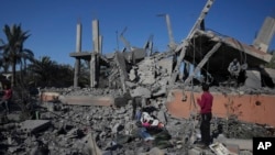 Palestinci provjeravaju ruševine uništene zgrade nakon noćnog izraelskog napada u Deir al-Balahu, Pojas Gaze, 4. decembra 2024.