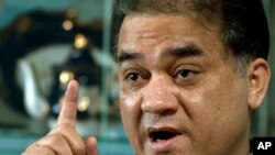 FILE - Ilham Tohti, a champion of China's Uighur minority who was jailed last year and whose plight is being highlighted by the "Press Uncuffed: Free the Press" campaign, gestures during an interview in his Beijing home, Feb. 4, 2013.