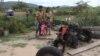 Kea Teav and her family stand in front of a two-wheeled tractor that was burnt down by a member of the Wildlife Alliance team in Krakor district, Pursat province, Cambodia, August 5, 2020. (Sun Narin/VOA Khmer)