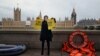 An activist from Amnesty International wearing a mask depicting Britain's Home Secretary Priti Patel, demonstrates ahead of the Government's Nationality and Borders Bill, opposite the Houses of Parliament, on the banks of the River Thames in London on Dec. 7, 2021.