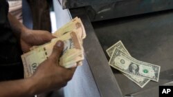 Venezuela Daily Life
지난 13일 베네수엘라 수도 카라카스의 한 상점에서 손님이 물건값을 내기 위해 베네수엘라 볼리바르화와 미국 달러화를 세고 있다.