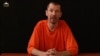An image taken from a video released by the Islamic State (IS) group through Al-Furqan Media via YouTube allegedly shows British freelance photojournalist, John Cantlie, at an undisclosed location in which he says he is being held captive, Sept. 18, 2014.